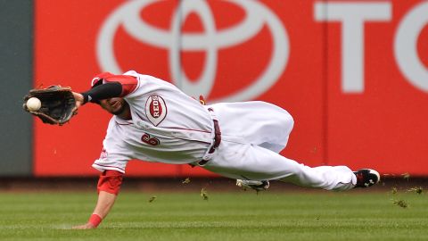 Billy Hamilton, de los Rojos, se lanza para hacer una gran atrapada durante el juego inaugural contra los Piratas.