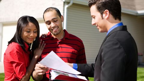 Un realtor muestra una casa a compradores.
