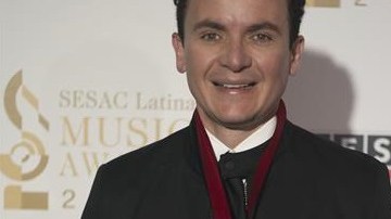 El cantante colombiano Fernando Fonseca presume presea en la alfombra roja de los premios SESAC Latina.