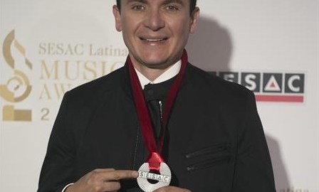 El cantante colombiano Fernando Fonseca presume presea en la alfombra roja de los premios SESAC Latina.