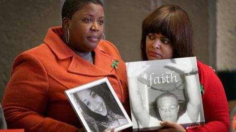 Cleopatra Cowley-Pendleton (izq.) muestra una foto de su hija Hadiya, 15, y Shundra Robinson otra de su hijo Deno Wooldridge, 18, durante una reunión de familiares y víctimas de la violencia armada y grupos de activistas defensores del control de armas en Cornell Square Park, de Chicago, Illinois, el 14 de diciembre 2013, en el aniversario de la masacre en la escuela primaria de Sandy Hook.