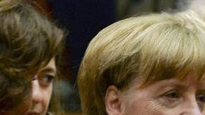 El primer ministro griego Alexis Tsipras  (der.), conversa con la canciller alemana Angela Merkel (izq.) y el presidente francés Francois Hollande (centro) al comienzo de la cumbre de líderes de la eurozona.