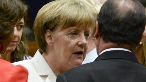 El primer ministro griego Alexis Tsipras  (der.), conversa con la canciller alemana Angela Merkel (izq.) y el presidente francés Francois Hollande (centro) al comienzo de la cumbre de líderes de la eurozona.
