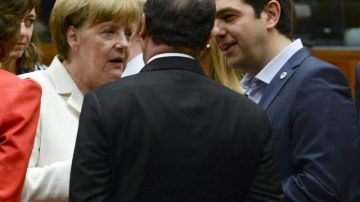 El primer ministro griego Alexis Tsipras  (der.), conversa con la canciller alemana Angela Merkel (izq.) y el presidente francés Francois Hollande (centro) al comienzo de la cumbre de líderes de la eurozona.