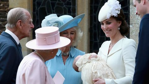 La Reina Isabel, en rosa, mira a la recién bautizada Charlotte, en brazos de su madre, Kate Middleton.