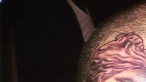 Chris también tiene tatuados una imagen de Jesús, un tiranosaurio rex y la cara de una mujer golpeada en su cuello.