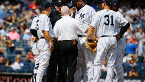 CC Sabathia, abridor de los Yankees, es atendido poco antes de abandonar el juego del domingo por lesión de la rodilla derecha.