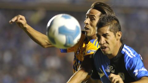 Lucas Lobos de Tigres (atrás) y Raul Rico (adelante) de Querétaro forcejean por el control de la redonda, durante el encuentro de anoche que no tuvo anotaciones.