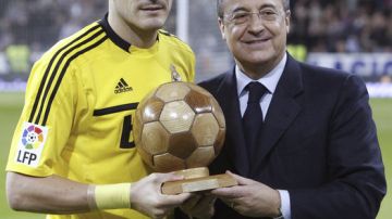 El presidente del Real Madrid, Florentino Pérez (derecha) le rinde homenaje al arquero y capitán del cuadro merengue,  Iker Casillas  (izquierda), antes de un recente juego de la Liga de España.
