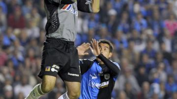 El balón queda en las manos de Enrique Palos, de Tigres, a quien observa José Enrique Ruiz de Querétaro en el partido del jueves.  Las semifinales siguen hoy.