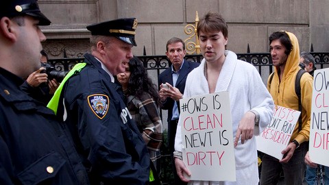Agentes policiales vigilan a los manifestantes para evitar se acerquen a la entrada del  Union League Club de Manhattan, donde el precandidato republicano Newt Gingrich asistía ayer a una reunión para recaudar fondos.