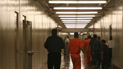 Indocumentados en poder de la migra caminan por un pabellón de un centro de detención en Georgia.