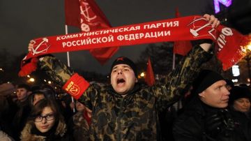 Un miembro del partido comunista ruso (c) corea lemas durante una concentración en Moscú para  protestar por los resultados de las elecciones rusas.