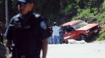 Empleados de medicina forense retiran de un auto el cuerpo de la periodista hondureña Luz Marina Paz, quien ejercía la profesión de manera independiente..