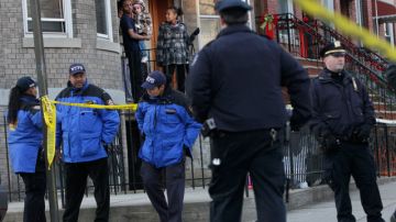 Vecinos de East New York, Brooklyn, observan a los policías que permanecían ayer cerca a la escena del crimen, donde cayó abatido el agente Peter Figoski.