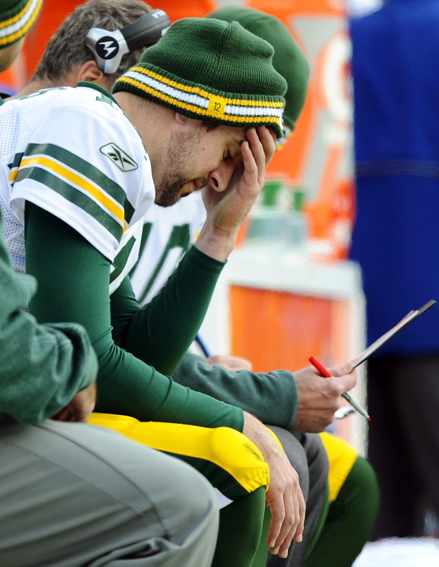 Aaron Rodgers, mariscal de campo de los Packers, toma un receso durante el juego del pasado domingo.