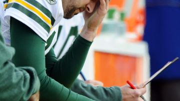 Aaron Rodgers, mariscal de campo de los Packers, toma un receso durante el juego del pasado domingo.
