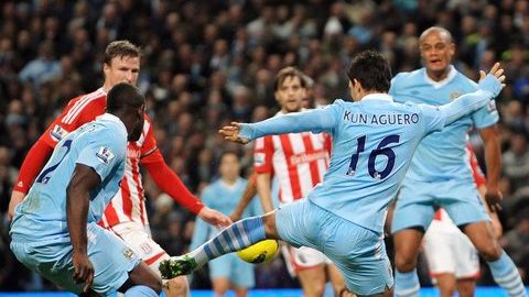 El argentino del Mánchester City, Sergio "Kun" Agüero (c, de espaldas) marca uno de sus dos goles en la victoria 3-0 frente al Stoke City.