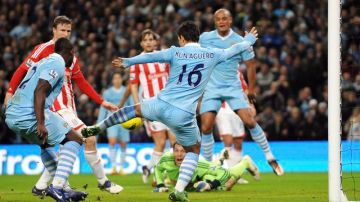 El argentino del Mánchester City, Sergio "Kun" Agüero (c, de espaldas) marca uno de sus dos goles en la victoria 3-0 frente al Stoke City.
