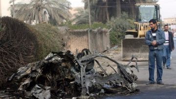 Un hombre contempla los restos de un coche bomba en un  barrio de   Bagdad.