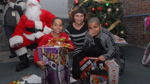 Jasmin Rodríguez junto a sus hijos Matías y Naishja Román, durante un evento de la Fortune Society que da regalos a niños de familias menos afortunadas.