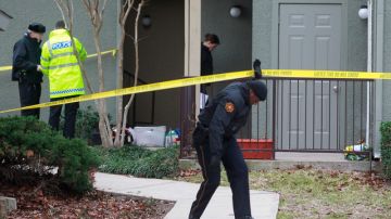 Un agente abandona la casa donde encontraron a siete personas muertas.