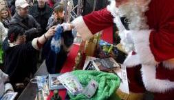 Un hombre disfrazado como Papá Noel entrega regalos en un puesto de "intercambio de presentes" en el mercado postnavideño.