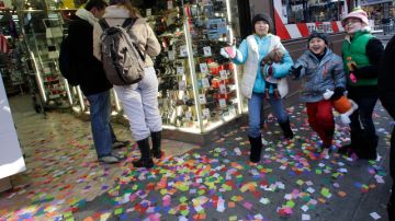 Turistas pasan por Times Square donde ayer se hizo la prueba de confeti, de cara a la celebración de mañana sábado.
