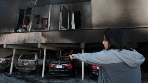 Eloísa Rentería señala hacia el lugar que sufrió daño tras el incendio en su edificio, en el bulevar North Cahuenga.