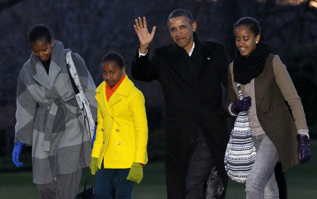 El presidente Barack Obama saluda a su regreso ayer a la Casa Blanca acompañado de su familia.