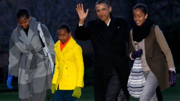 El presidente Barack Obama saluda a su regreso ayer a la Casa Blanca acompañado de su familia.