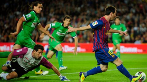 El argentino Lionel Messi del Barcelona anota un gol tras dejar atrás a la defensa y al portero del Racing de Santander.