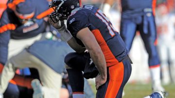 Tim Tebow, quarterback de los Broncos de Denver, orando.