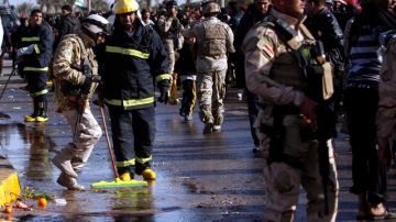 Varios oficiales de seguridad iraquíes visitan el lugar donde se ha producido un ataque suicida con bomba en Basora, ayer.