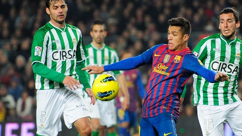 El chileno Alexis Sánchez, aquí marcado por dos hombres del Betis, fue determinante ayer para que el cuadro 'culé' ganara en el Camp Nou.