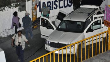 Expertos forenses y militares investigan en torno a los vehículos donde siete presuntos sicarios murieron en el centro de México.