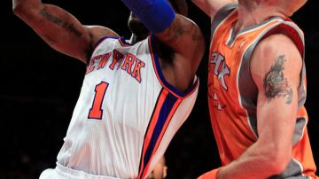 Marcin Gortat (4) de los Suns, bloquea un intento de anotar de Amar'e Stoudemire, de los Knicks.