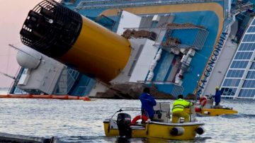 Técnicos de medio ambiente instalan barreras flotantes alrededor del crucero "Costa Concordia", semihundido junto a la isla de Giglio, Italia.