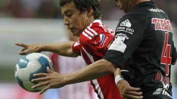 El jugador de Chivas, Erick Torres Padilla (izq.) disputa el balón con Miguel Almazán Quiróz de Tijuana, durante el juego que perdió Guadalajara por 2-0.