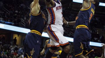 Carmelo Anthony (centro) penetra la defensa de Anthony Parker (izq.) y Kyrie Irving (der.), de los Cavaliers, en la más reciente presentación de los Knicks.