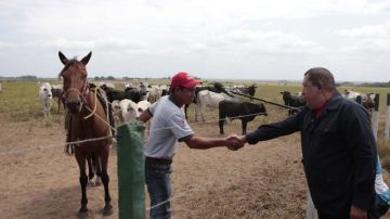 El presidente venezolano Hugo Chávez (d) saluda a un campesino durante parte de su programa dominical 'Aló Presidente' desde la localidad de Santa Ana.