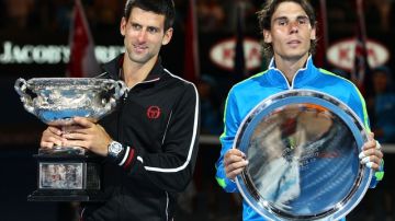 El español Rafael Nadal (der.) y el servio Novak Djokovic, posan con los trofeos de segundo y primer lugar, respectivamente, conquistados ayer en la final la final más larga de la era abierta en los Grand Slams (5:33), en Australia.