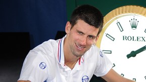 Presumiendo su trofeo, Novak Djokovic posa junto al reloj que marca 5:53: el tiempo que duró su juego.