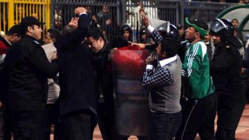 Policías y aficionados egipcios se enfrentan en el estadio de Port Said, Egipto.