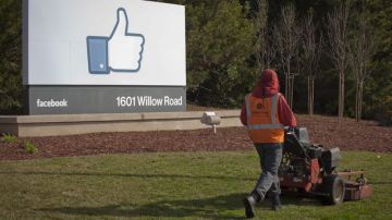 Un empleado corta el césped frente al cuartel general de la red social Facebook en Menlo Park, California.