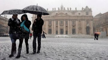 El departamento de viabilidad del Ministerio italiano del Interior recomendó no viajar si no es estrictamente necesario. Turistas caminan durante una fuerte nevada ayer en la plaza de San Pedro .