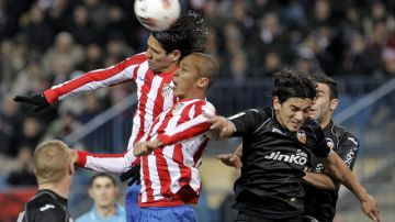 Radamel Falcao (izq.) y Joao Miranda pelean en el aire por un balón con defensas del Valencia, ayer, en el Vicente Calderón.