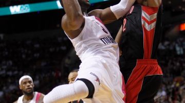 Dwayne Wade (izq.), del Heat de Miami, intenta anotar frente a James Johnson (der.) de Toronto Raptors.