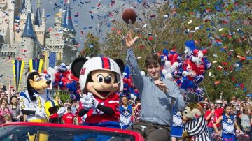 Eli Manning, el JMV de los Gigantes, se divierte al lado de Mickey Mouse durante el desfile de celebración en Disney.