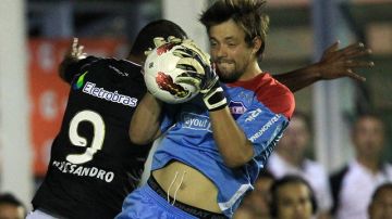 Alecsandro (izq.), del Vasco de Gama, disputa el balón con el arquero Burián,  del Nacional de Uruguay, en el encuentro de ayer.